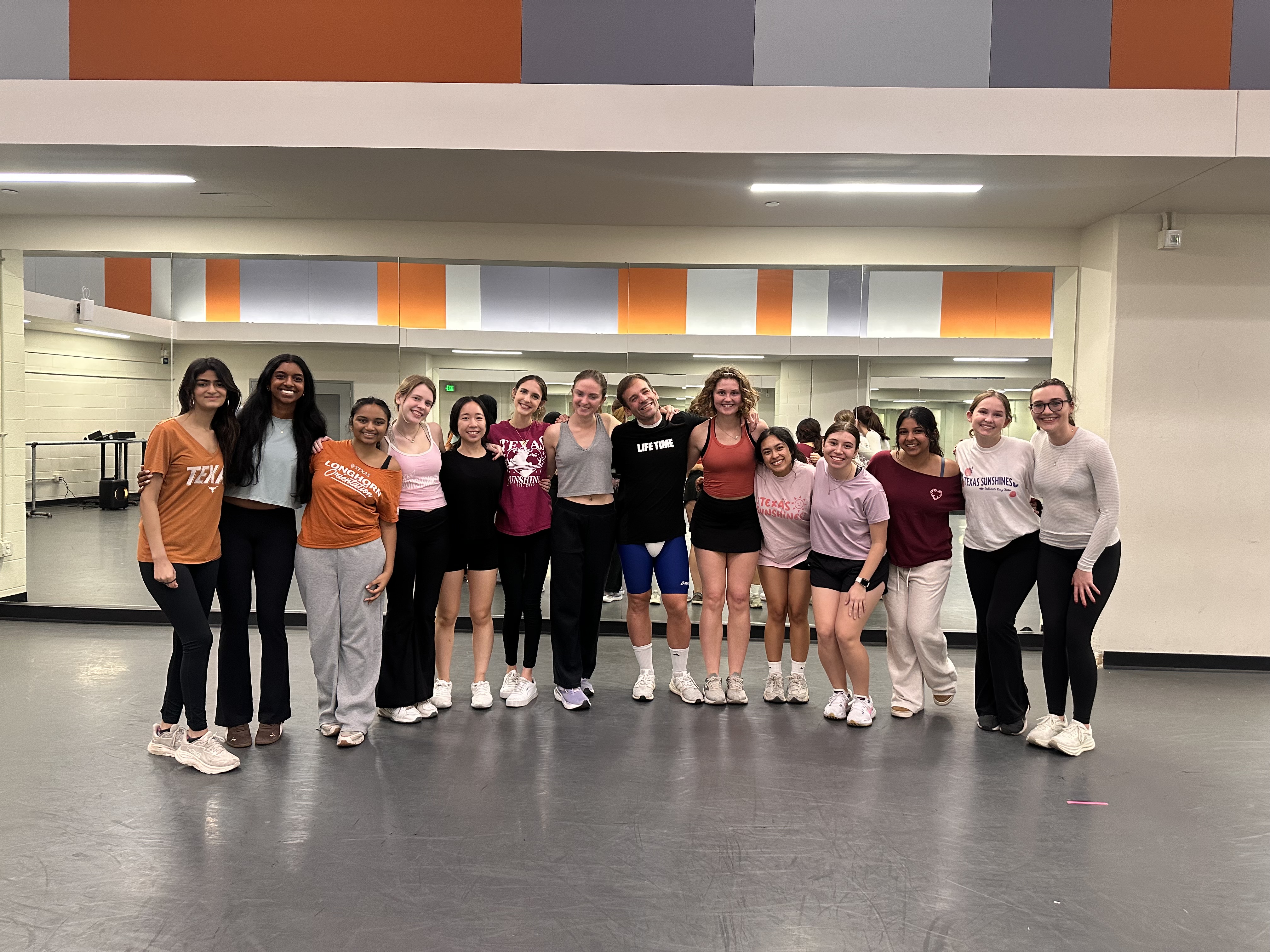 Sixteen smiling participants and Jesse after a Kick His Dick self-defense class