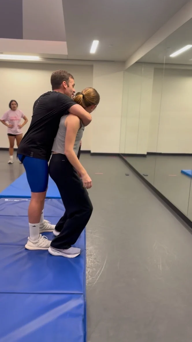 A woman practicing a standing choke escape with Jesse